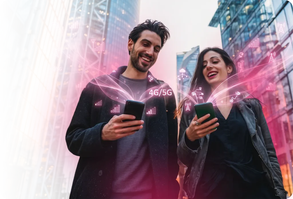 A smiling man and woman standing close together on a city street at night, each holding a smartphone, with vivid pink-magenta 4G/5G network graphics, signal bars, towers, and connectivity data visualisations emanating from their devices - illustrating next-generation mobile connectivity and real-time telecom data exchange