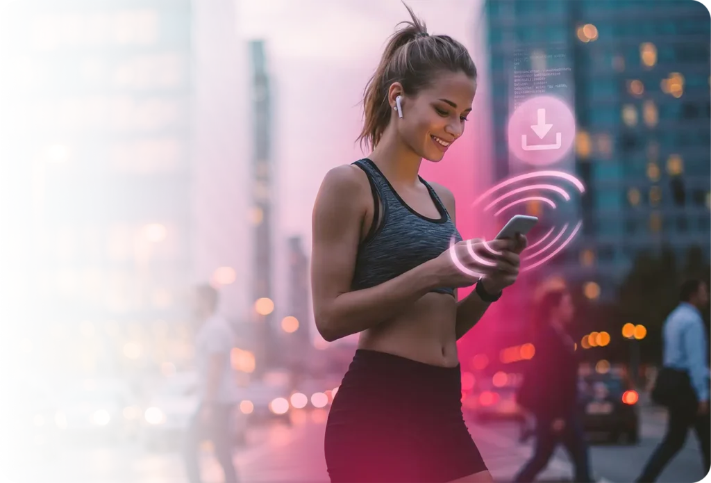 Joven mujer atlética en ropa deportiva sonriendo mientras mira un smartphone en una calle de la ciudad al anochecer, con auriculares inalámbricos y un ícono de descarga/señal circular rosa brillante flotando junto a su dispositivo - que representa a una suscriptora móvil interactuando con contenido de aplicación o una notificación push a través de una red de telecomunicaciones 5G